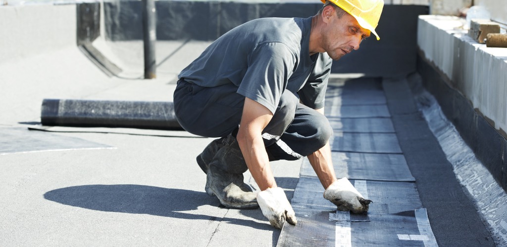 installing black roofing membranes on a flat roof